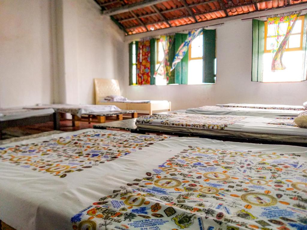 a room with three mattresses on the floor with windows at Hostel Ateliê Laroyê in Salvador