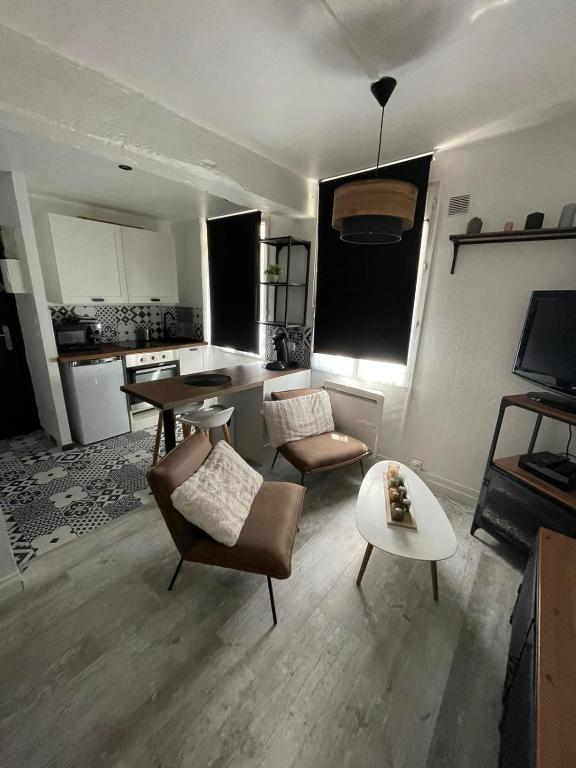 un salon avec un canapé, des chaises et une table dans l'établissement studio Nicaise, à Rouen