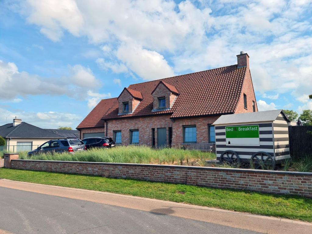 une maison avec une remorque garée devant elle dans l'établissement B&B The Beachhouse, à Oostduinkerke