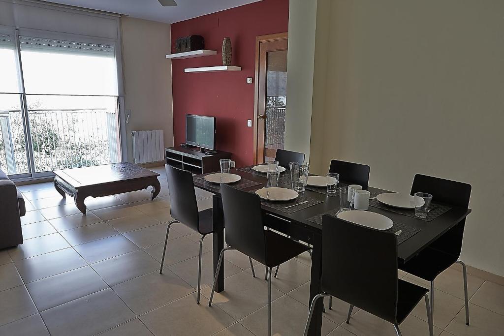 a dining room with a black table and chairs at Alguera Apartments Sant Andreu in Barcelona