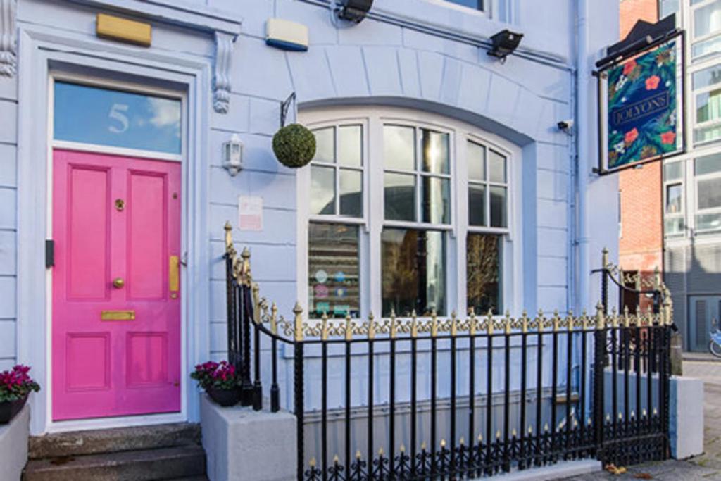 a pink door on a house with a fence at higgihaus #5 5 of 7 Rooms Monday - Friday in Cardiff