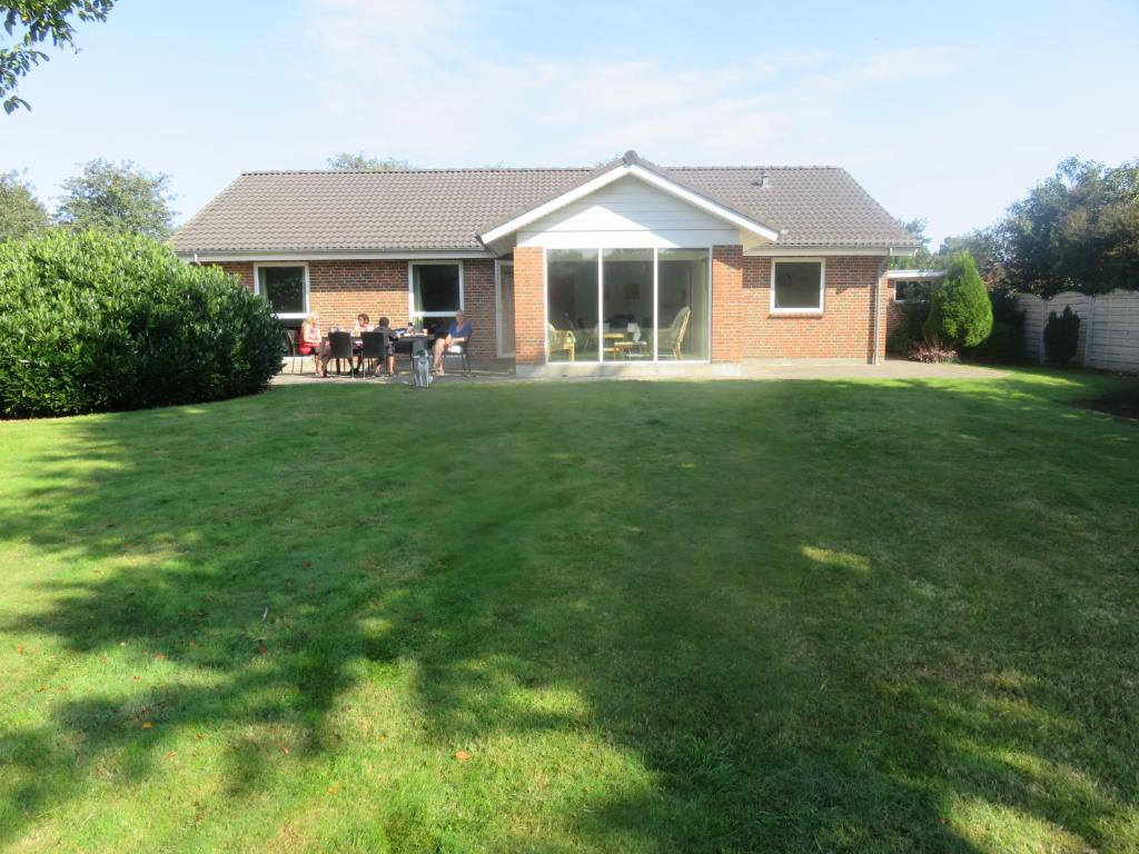 ein Haus mit Rasen davor in der Unterkunft Gudená Riverview Villa in Bjerringbro