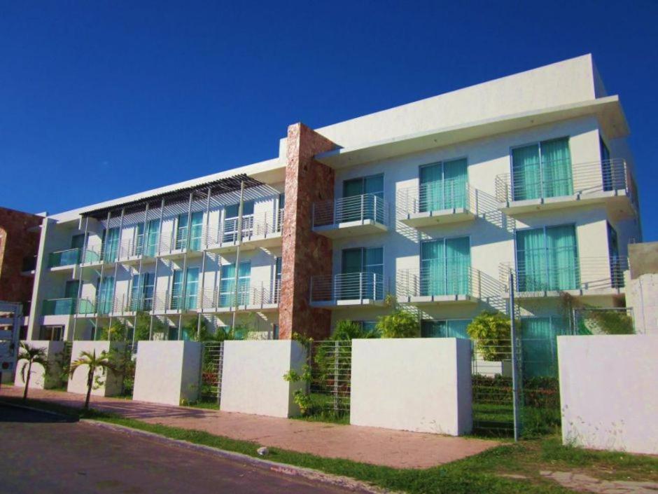 um edifício de apartamentos com uma cerca em frente em Hotel Noor em Chetumal