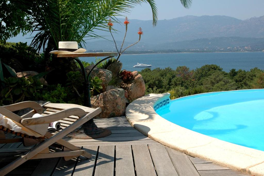 a swimming pool next to a chair and a chair at Résidence Alt'aria in Porto-Vecchio