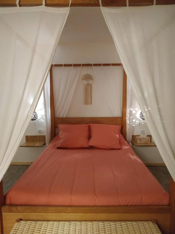 Cette chambre comprend un lit avec un couvre-lit orange. dans l'établissement La ferme des Escampades, à Monteux