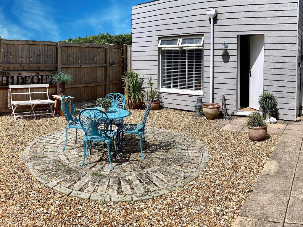 a patio with a table and chairs in a yard at The Hideout in Chichester