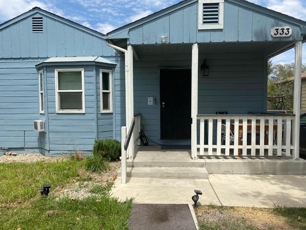 une maison bleue avec une véranda et une porte dans l'établissement WHOLE Family - Barrette (front), à Sacramento