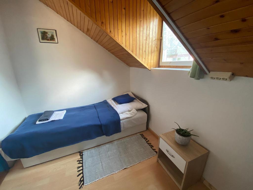 mała sypialnia z łóżkiem i oknem w obiekcie Kék Nefejelcs apartman w mieście Bükkszentkereszt