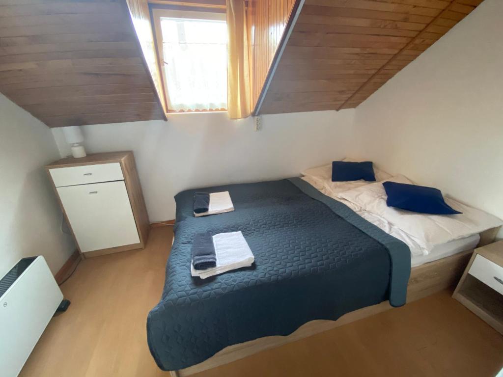 mała sypialnia z łóżkiem i oknem w obiekcie Kék Nefejelcs apartman w mieście Bükkszentkereszt