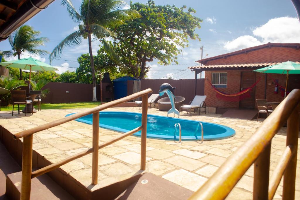 a swimming pool with a slide in a backyard at Noronha Good Vibes Hostel in Fernando de Noronha