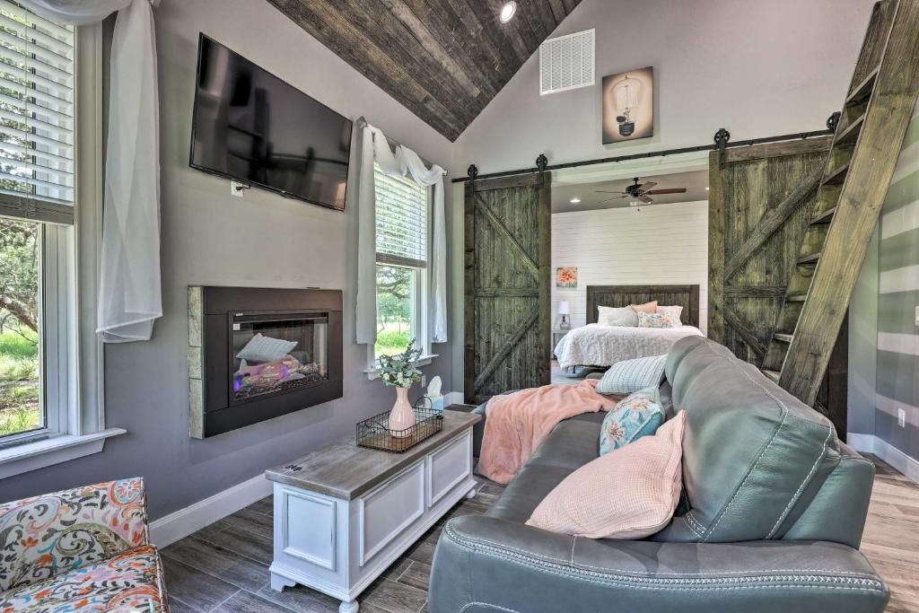 a living room with a couch and a bed and a fireplace at Cozy Spring Branch Cottage in Hill Country! in Spring Branch