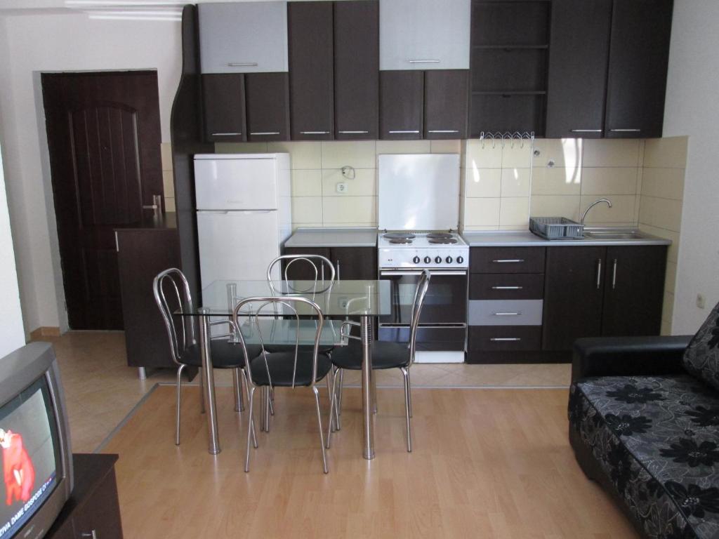 eine Küche mit einem Glastisch mit Stühlen und einem Sofa in der Unterkunft Tatjana's Apartments Ohrid in Ohrid