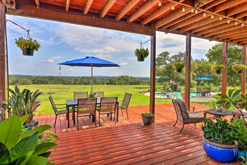 a wooden deck with a table and chairs and an umbrella at Extravagant 4,500 Sq Ft Home in Hill Country! in Spring Branch