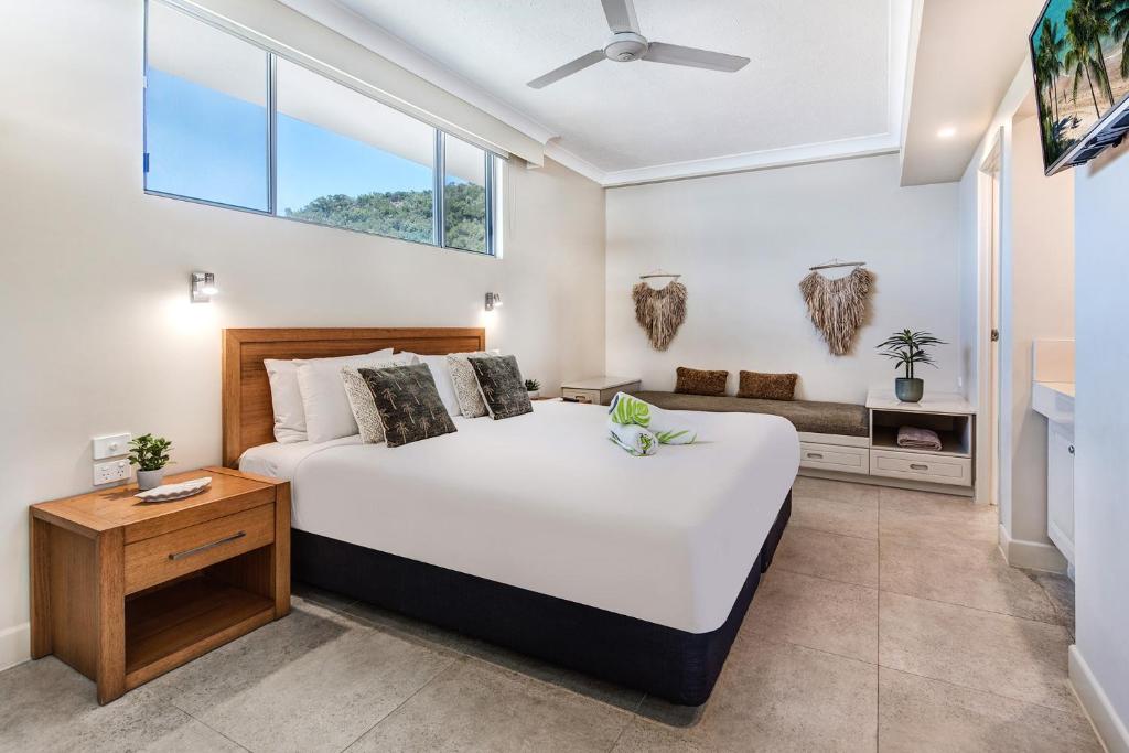 a bedroom with a large bed and a window at Whitsunday East 1106 on Hamilton Island by HamoRent in Hamilton Island