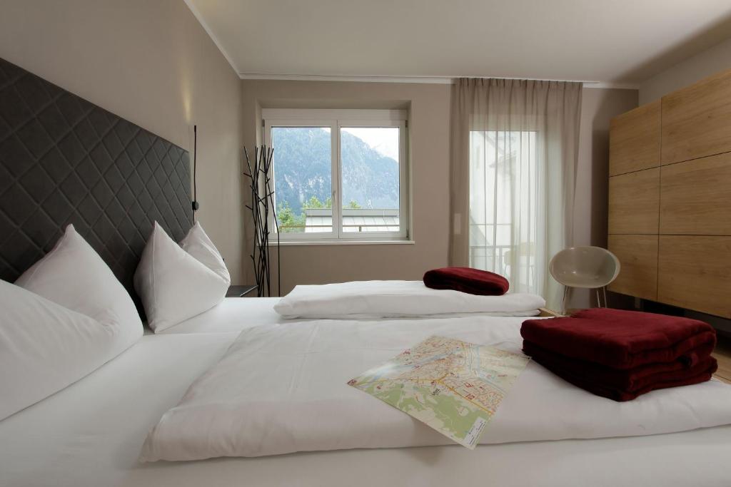 a bedroom with two white beds and a window at Apartmenthaus Nr 1 in Lienz