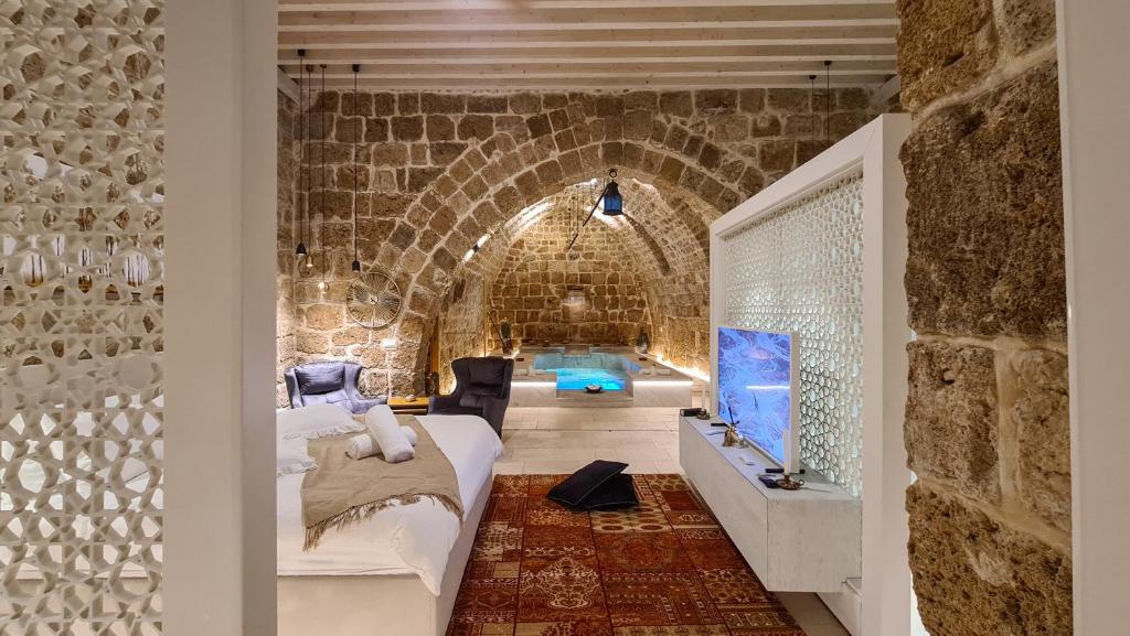 1 dormitorio con 1 cama en una pared de ladrillo en Dalaa, en Acre