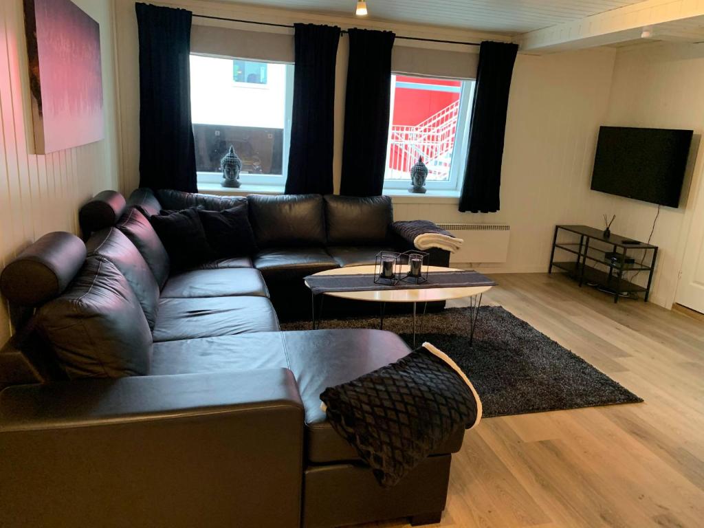 a living room with a leather couch and a table at Notodden Sentrum Apartment NO 1 in Notodden