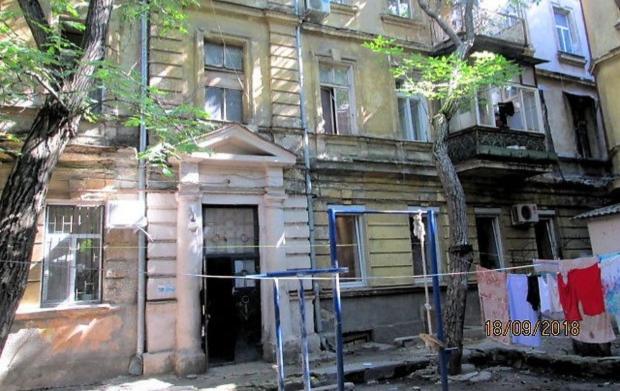 ein altes Haus mit Kleidern an einer Wäscheleine in der Unterkunft Apartament Park3 in Odessa