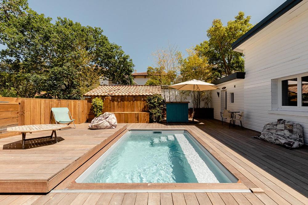 - une petite piscine sur une terrasse en bois à côté d'une maison dans l'établissement Board 'n Breakfast, à Labenne