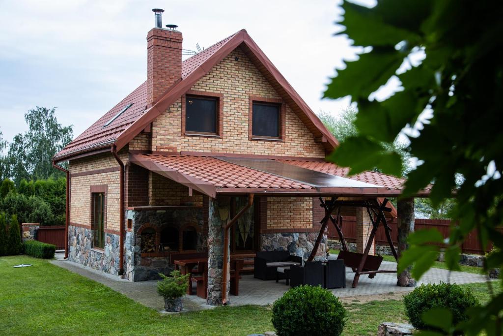 Leśne zacisze- rowery,łódka,kajak في Kallinowen: منزل من الطوب مع سقف مع فناء