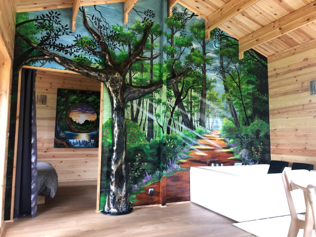a mural of a tree on the wall of a room at Chalet au Natur'Heil Nature-Spa-Gourmandise in Wahlbach