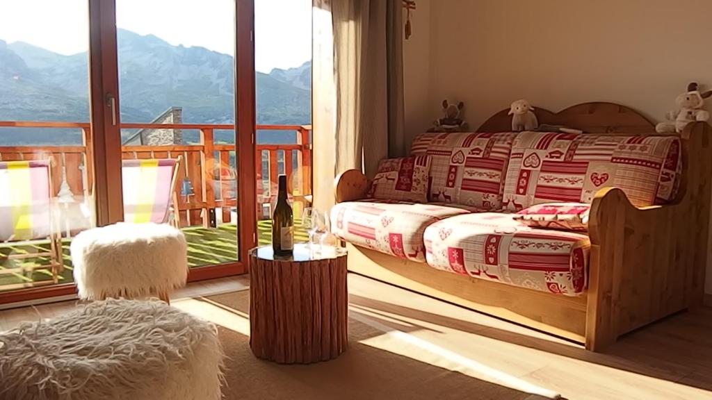 Un dormitorio con una cama con vista a un balcón. en Appartement 8 personnes à 3 minutes des pistes, en Le Dévoluy