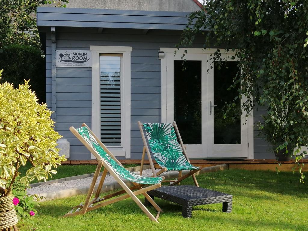 two lawn chairs sitting in front of a house at Moulin Room in Naours