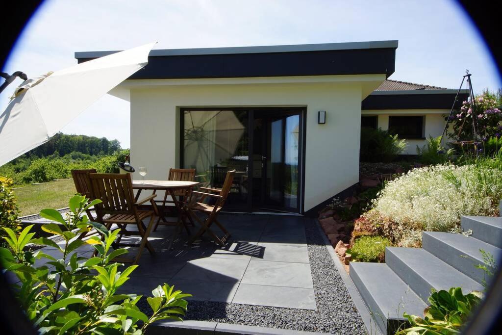 a patio with a table and an umbrella at Ruhe Oase mit tollem Fernblick inmitten der Natur in Limbach