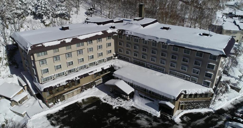 an aerial view of a building covered in snow at Shiga Park Hotel in Yamanouchi