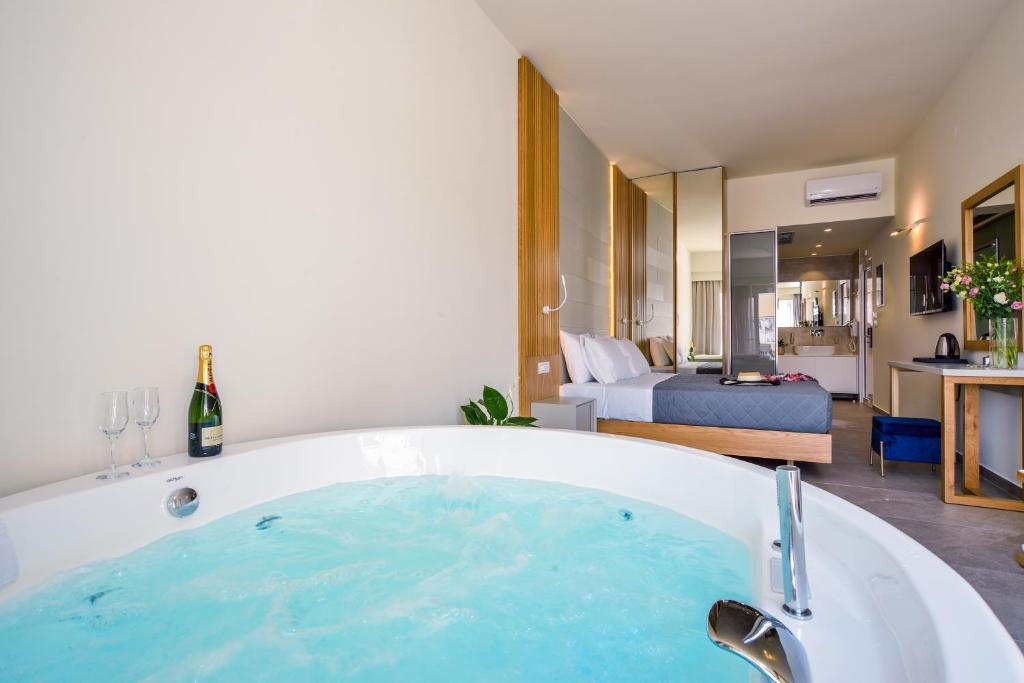 a bath tub in a room with a bedroom at Elia Platanias in Platanias