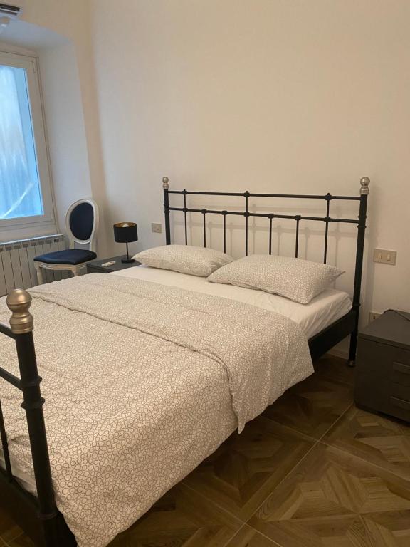 a bedroom with a large bed with white sheets and a window at La camera in centro ( 1 minute from Piazza Unita) in Trieste