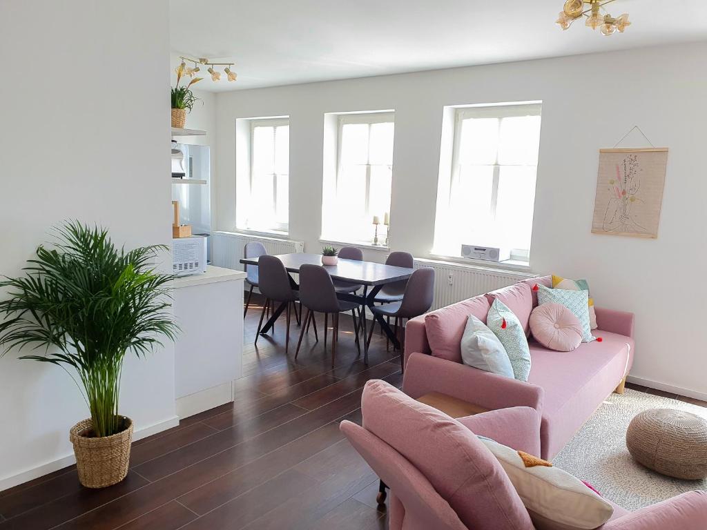 a living room with a pink couch and a table at PB Ferienwohnungen - FeWo 7 - Stilvoll eingerichtetes Apartment im Herzen Senftenbergs in Senftenberg