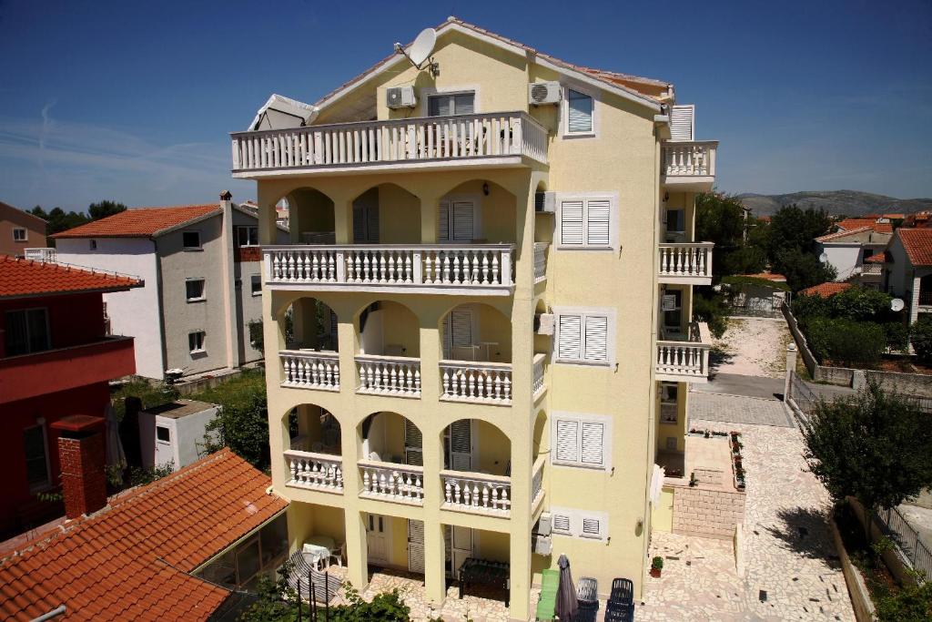 Cette chambre offre une vue aérienne sur un bâtiment jaune et dispose d'un balcon. dans l'établissement Apartments Zdravko, à Trogir