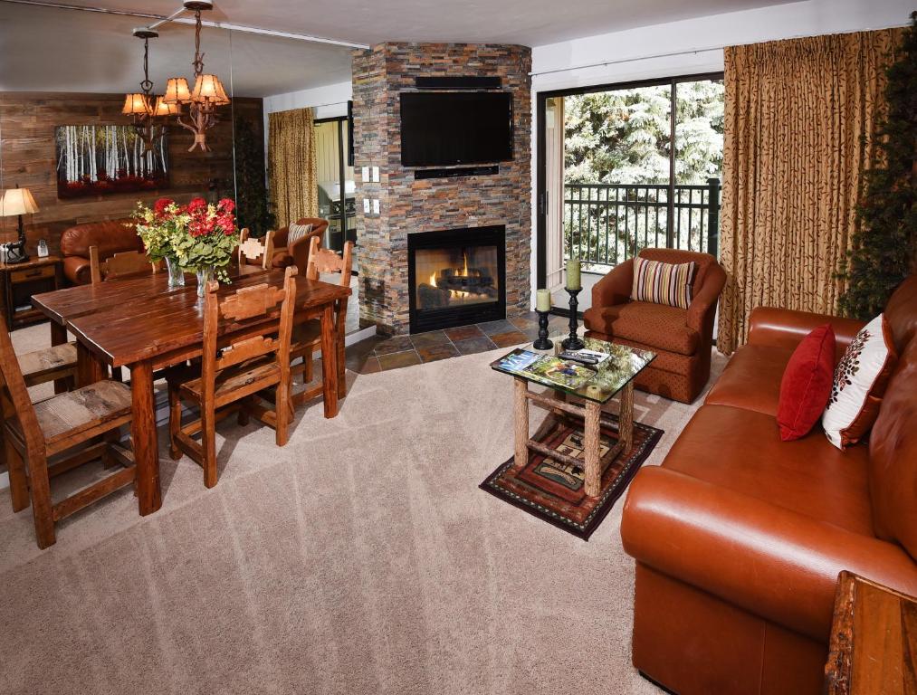 a living room with a table and a fireplace at Vantage Point #209 Condo in Vail