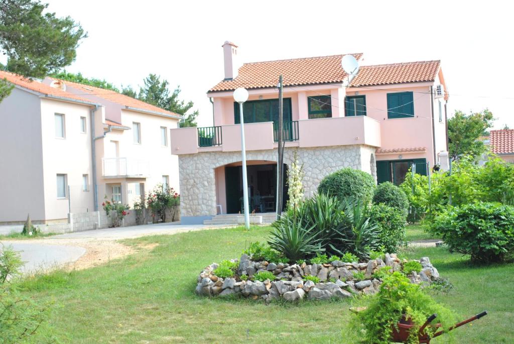 a house with a pile of rocks in the yard at Apartments Sunny Punta in Privlaka