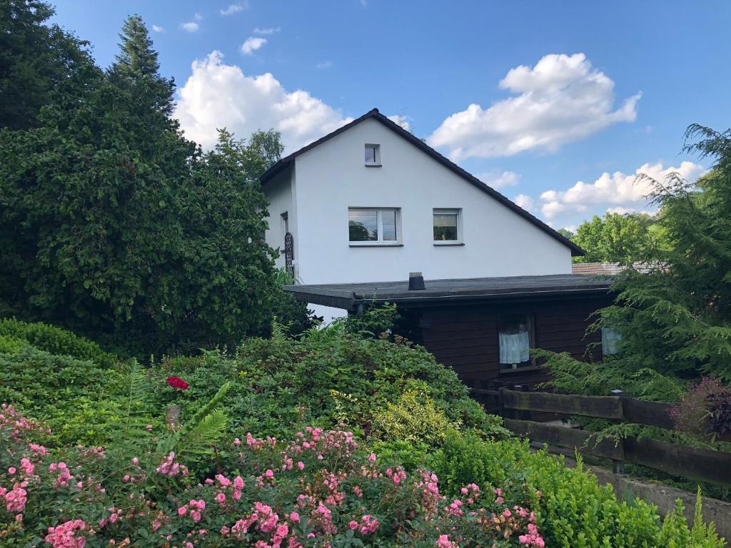 una casa blanca con flores delante en Ferienwohnung Donner am Wald mit Garten & Hot-Tub, en Meschede