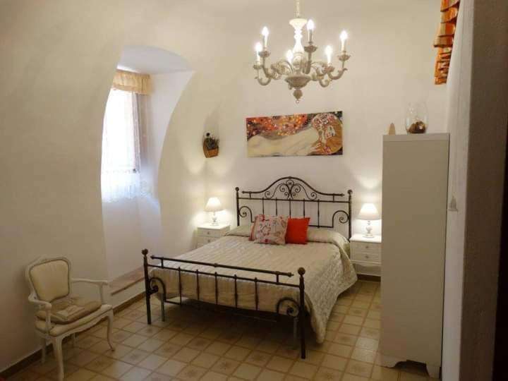 una camera con letto, sedia e lampadario a braccio di B&B Goriano Valli a Goriano Valli
