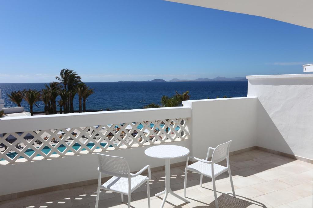 a balcony with a table and chairs and the ocean at Iberostar Selection Lanzarote Park in Playa Blanca