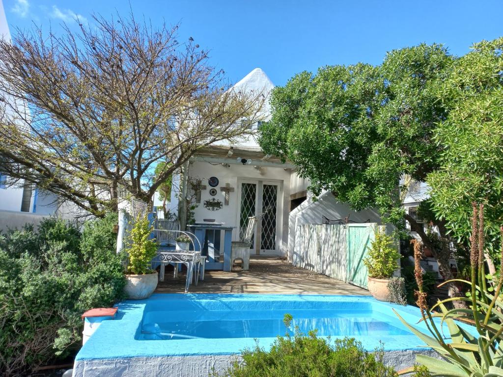 a swimming pool in front of a house at Hocus Pocus Cottage in Paternoster