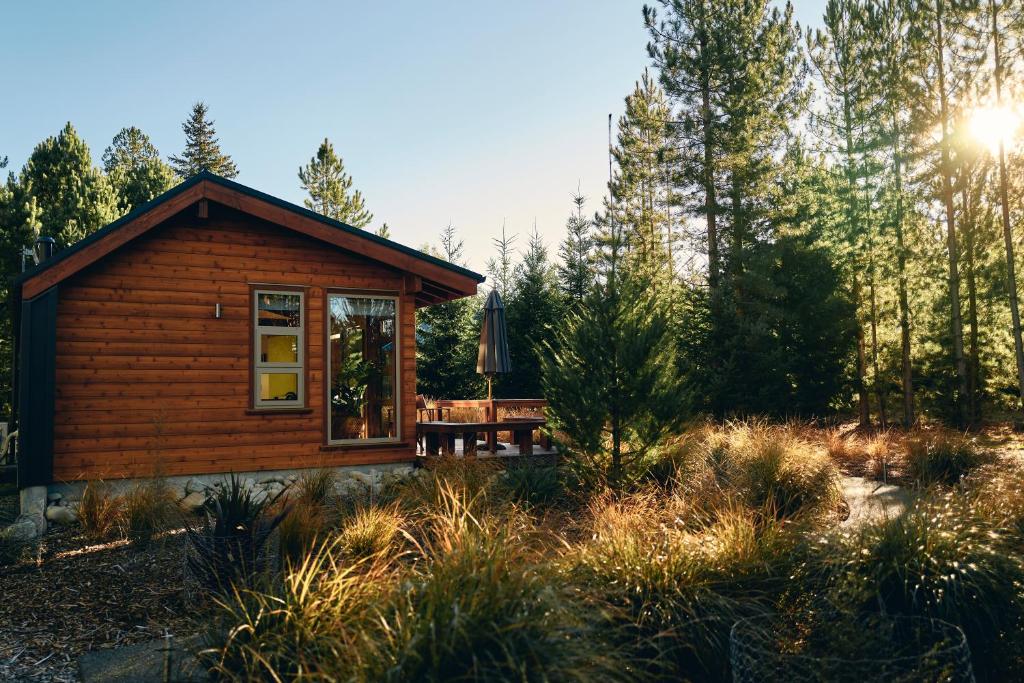 a log cabin in the middle of a forest at Kowhai Cottages - Stunning Mackenzie in Twizel