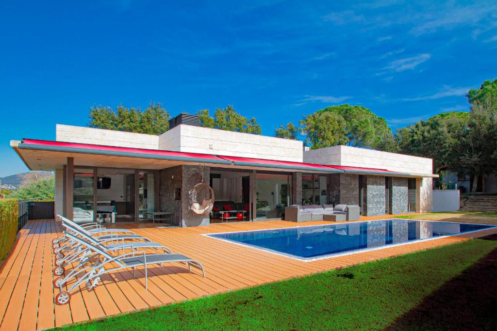 uma casa com um deque e uma piscina em Club Villamar - Piamonte em Calonge