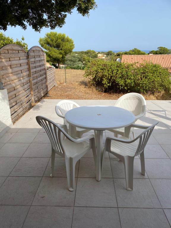 uma mesa branca e cadeiras sentadas num pátio em Location 5 personnes Sant Ambroggio Cocody village em Lumio
