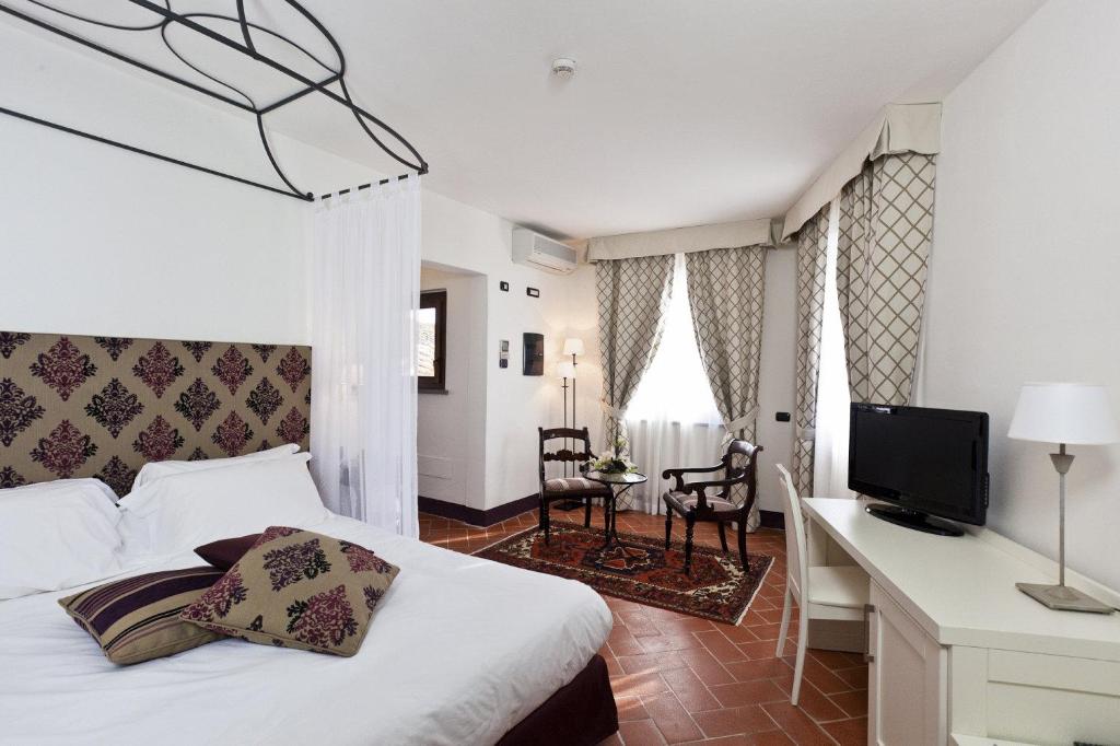 a bedroom with a bed and a desk and a television at Hotel San Miniato in San Miniato