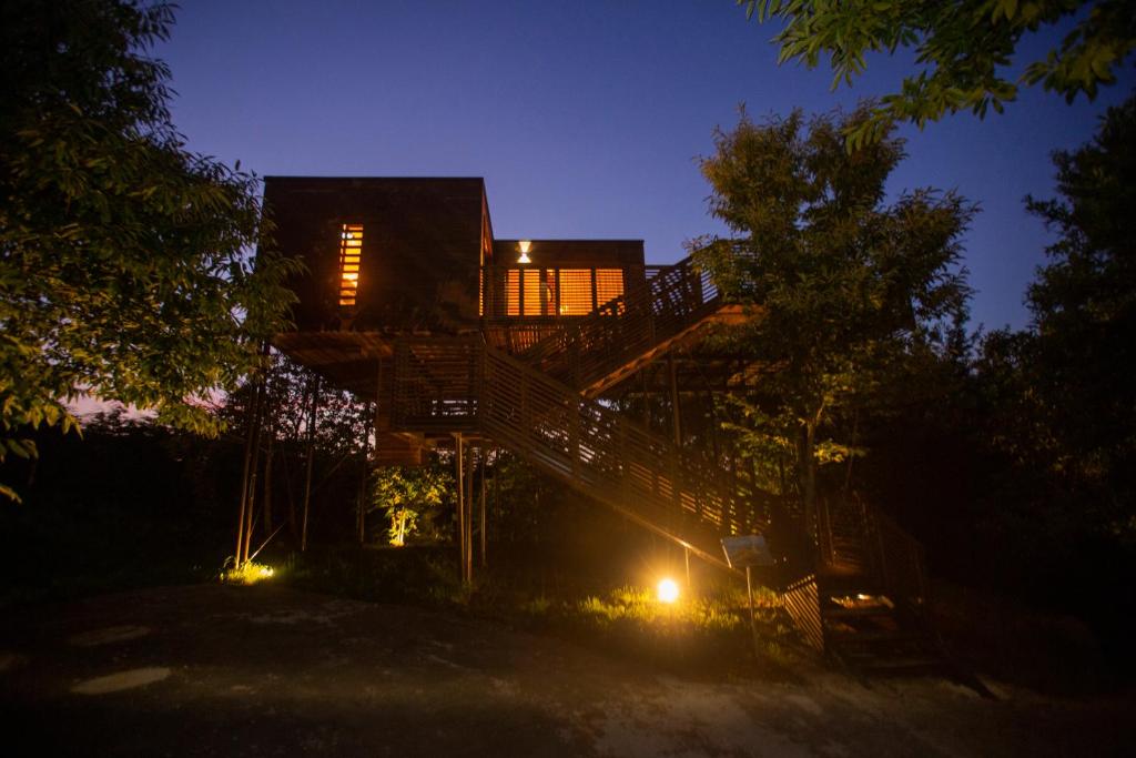 una casa por la noche con una escalera y luces en cabañas en el árbol costa da morte, en Muxía