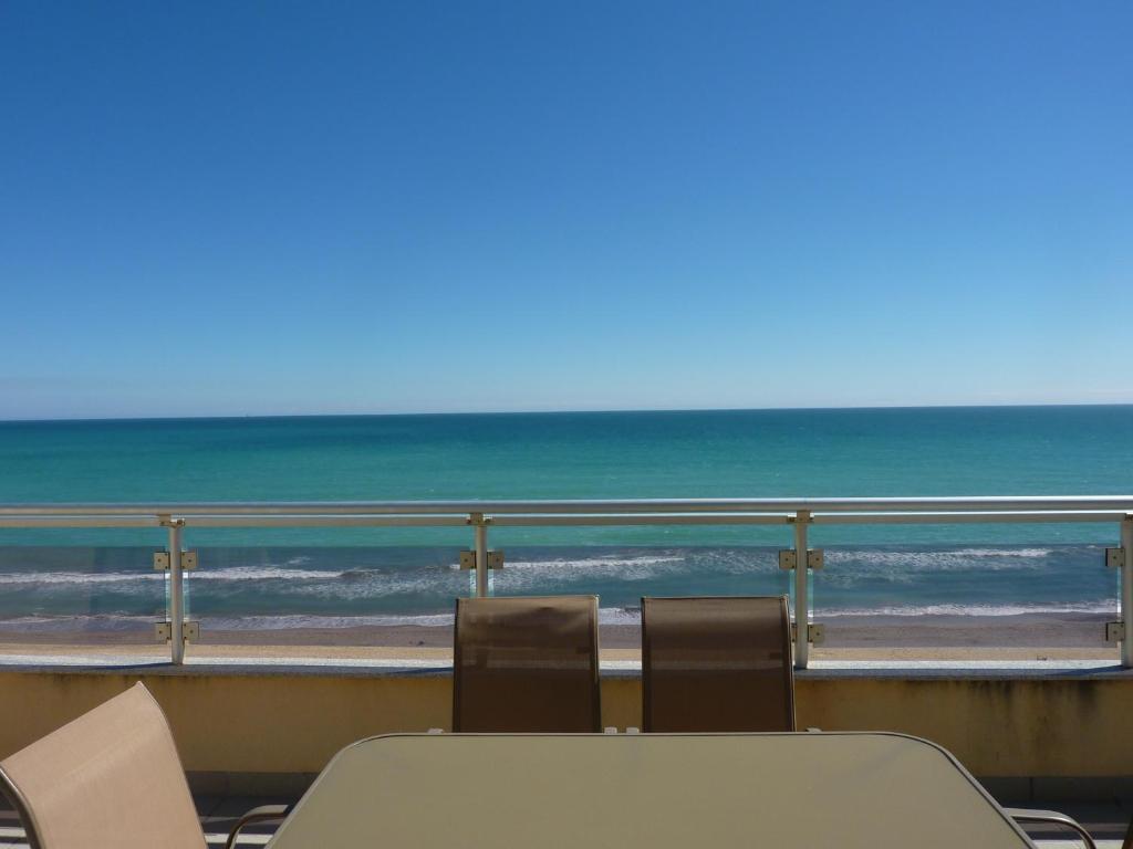 una mesa y sillas en un balcón con vistas al océano en Apartamentos Boutique Pompeya, en Peñíscola