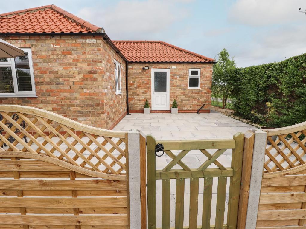 a wooden fence with a patio in front of a house at The New Build in Louth