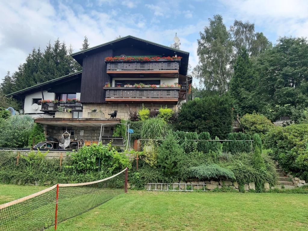 uma casa com um campo de ténis em frente em Apartmány Tereza em Albrechtice v Jizerskych horách