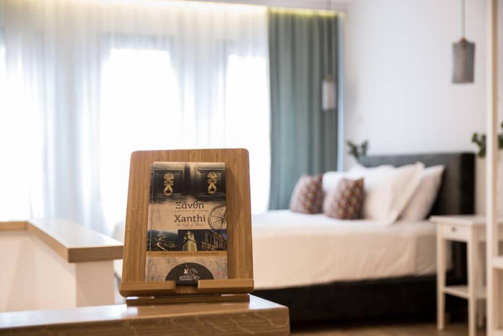 una camera con un letto e un orologio su un tavolo di Isidorou Suite Xanthi a Xánthi