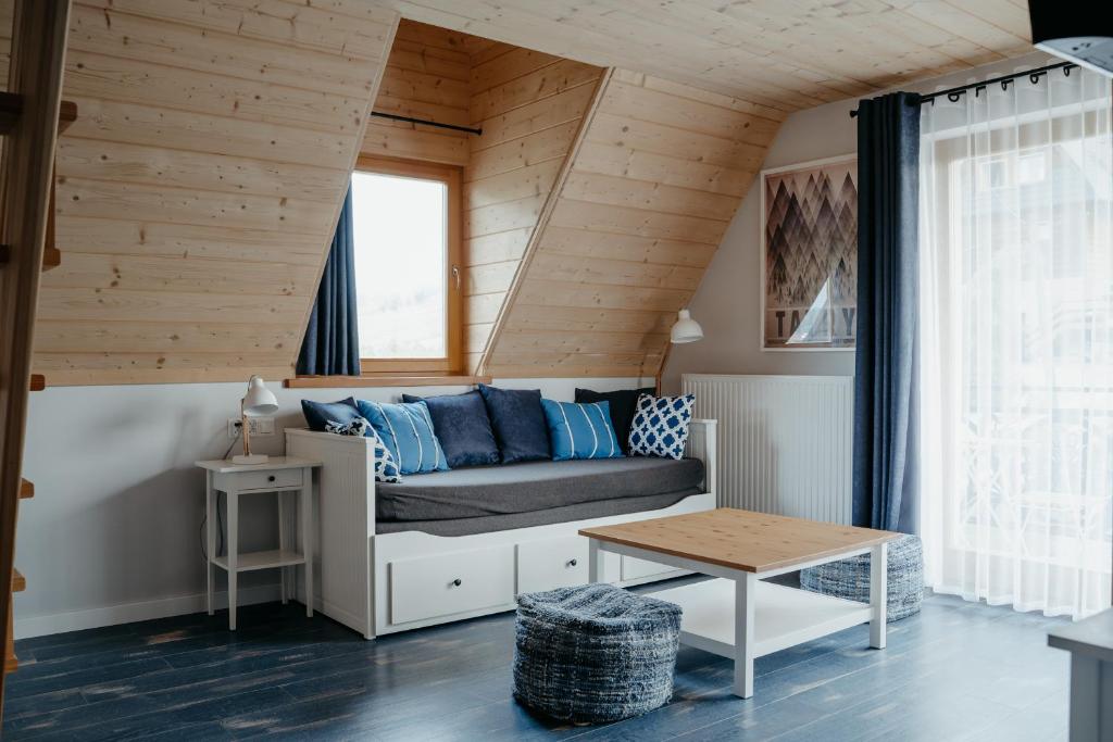 a living room with a couch and a table at Osada Witów - apartament „Niebieska Turnia” in Witów