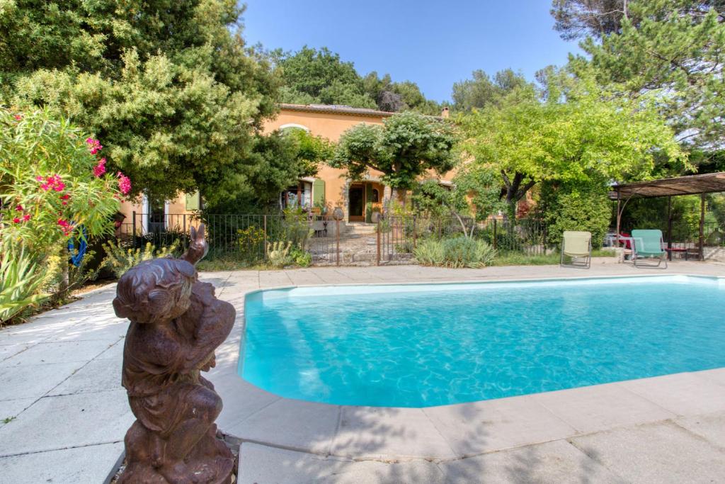 una estatua junto a una piscina en Mas de Bacalan, en Mormoiron